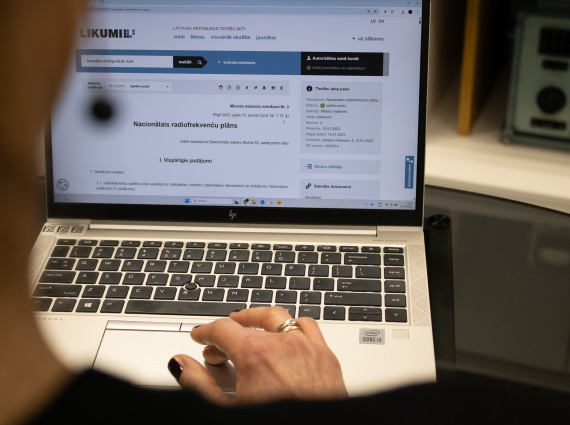 Datora ekrānā atvērts Nacionālā radiofrekvenču plāns likumi.lv vietnē; persona to pārlūko.